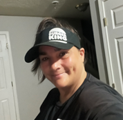 Headshot photo of Sheila Jeffery, a white female with dark hair wearing a black Burger King cap and shirt