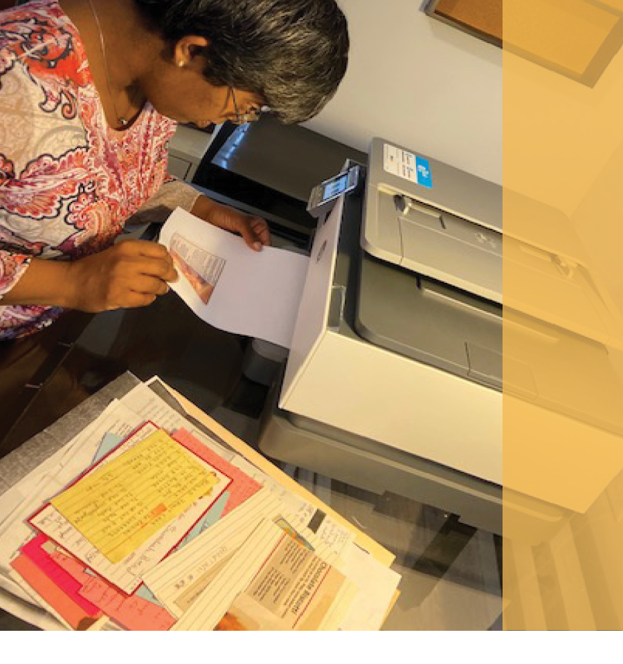 Nandi Isaac is sitting at her desk printing documents.