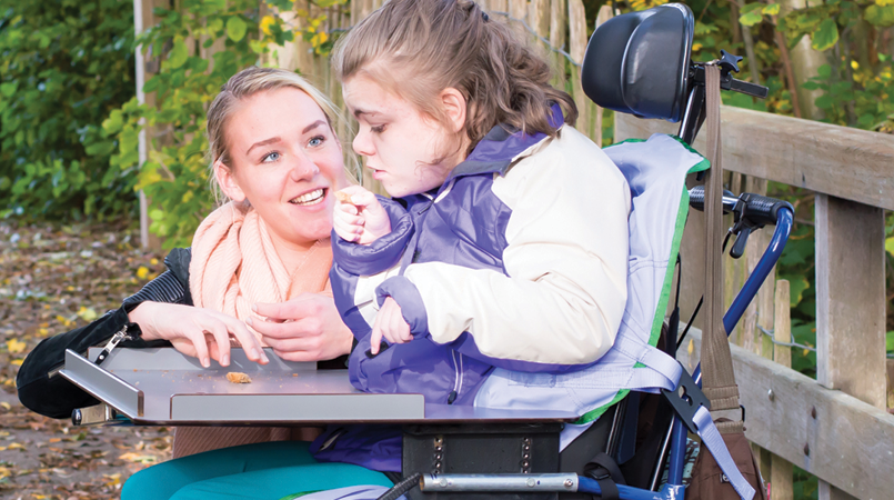 Photo of a Direct Support Professional with her client, who is a wheelchair user.